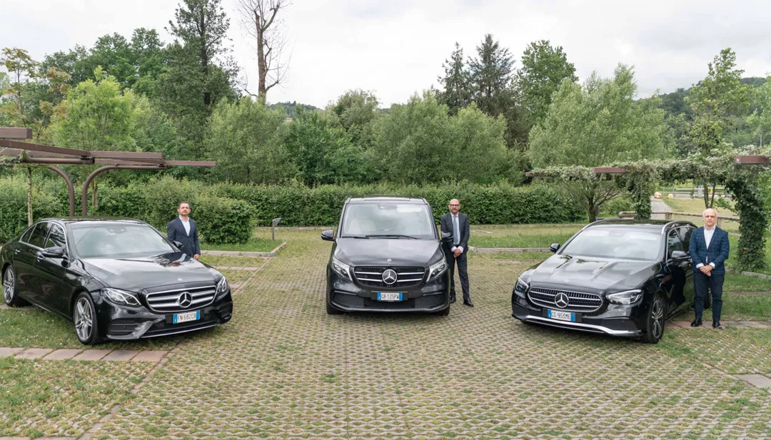 Tre autisti Elite accanto a due berline e un van Mercedes